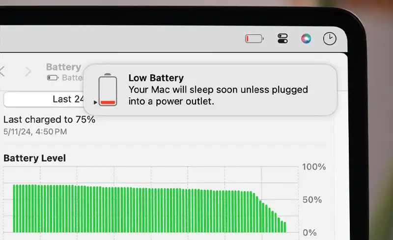Ecran MacBook cu Settings — Battery deschis, arata Battery Level grafic cu istoric de descarcare rapida si notificare iOS „Low Battery: Your Mac will sleep soon unless plugged into a power outlet" — autonomie redusa drastic